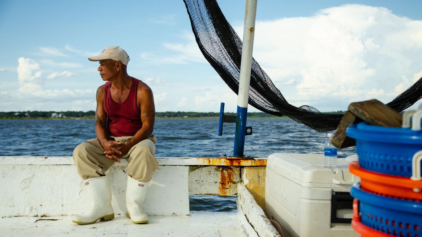 A deck hand looks out over the sea.