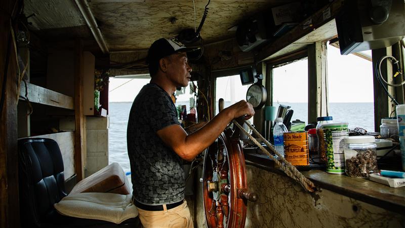 Dung Van Nguyen navigates the Captain Anthony out of the harbor in Ocean Springs, Mississippi.