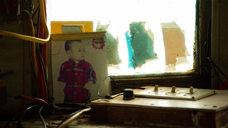 A sun-faded photo of Captain Dung's child sits near the helm.